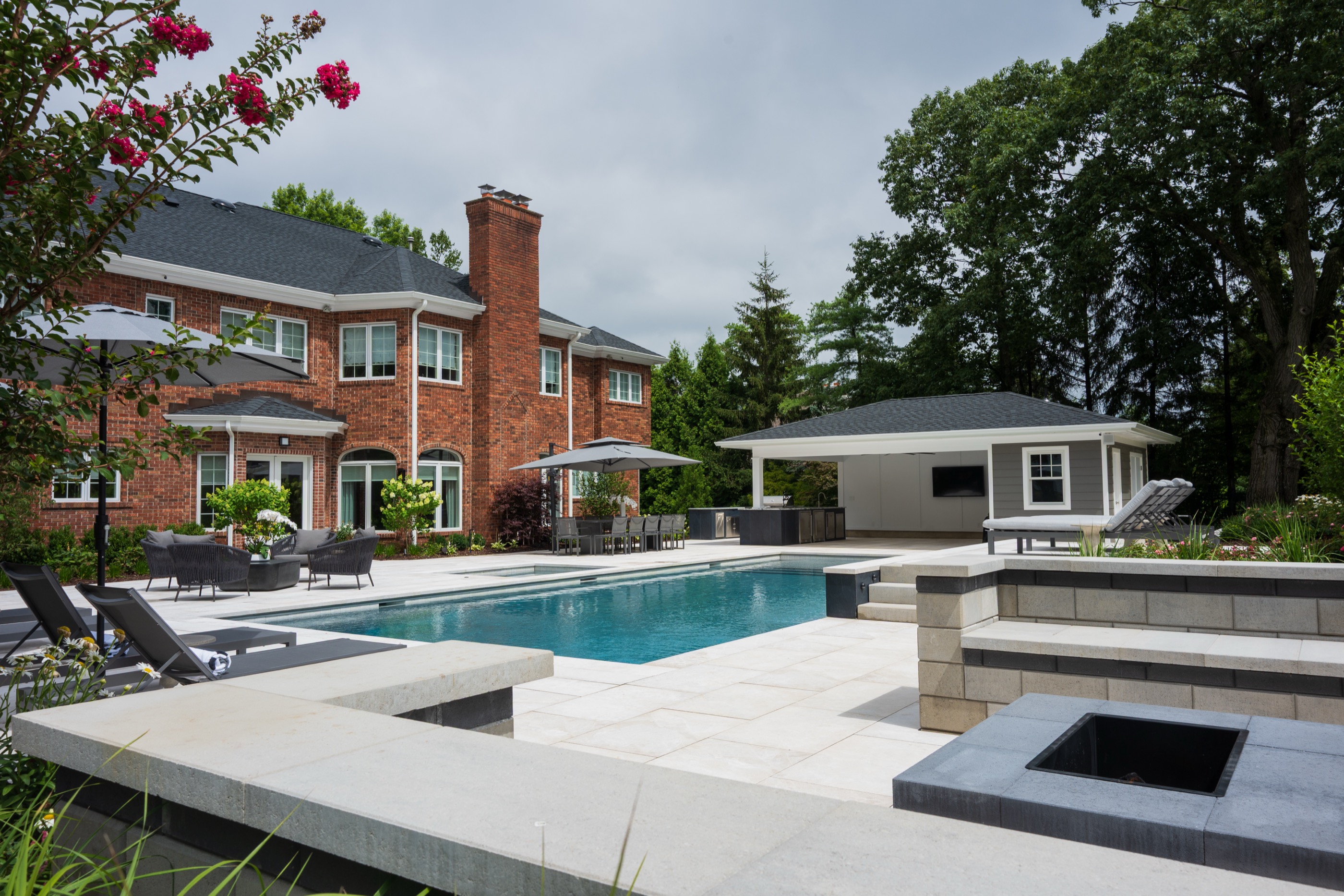 Brick colonial estate with geometric pool, raised spa, and pavilion