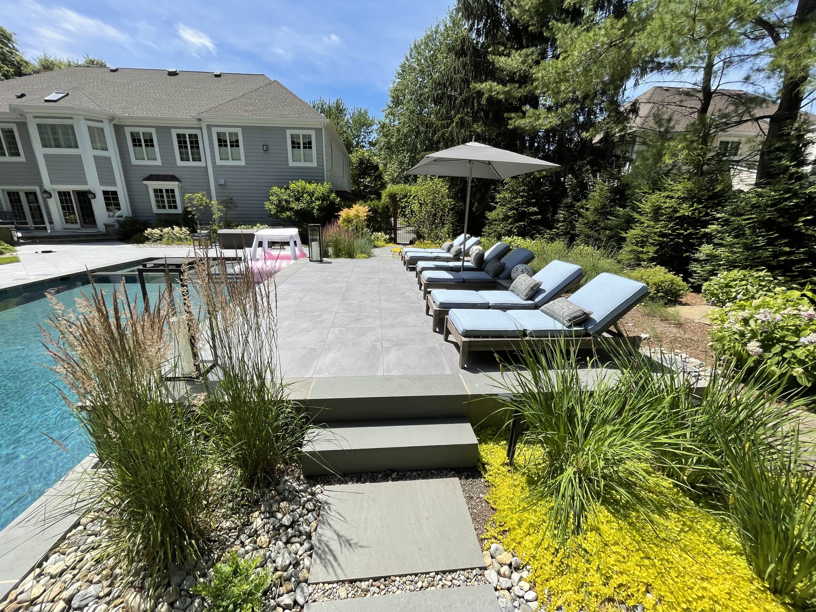 Pool with grass-paver steps and modern lounge area