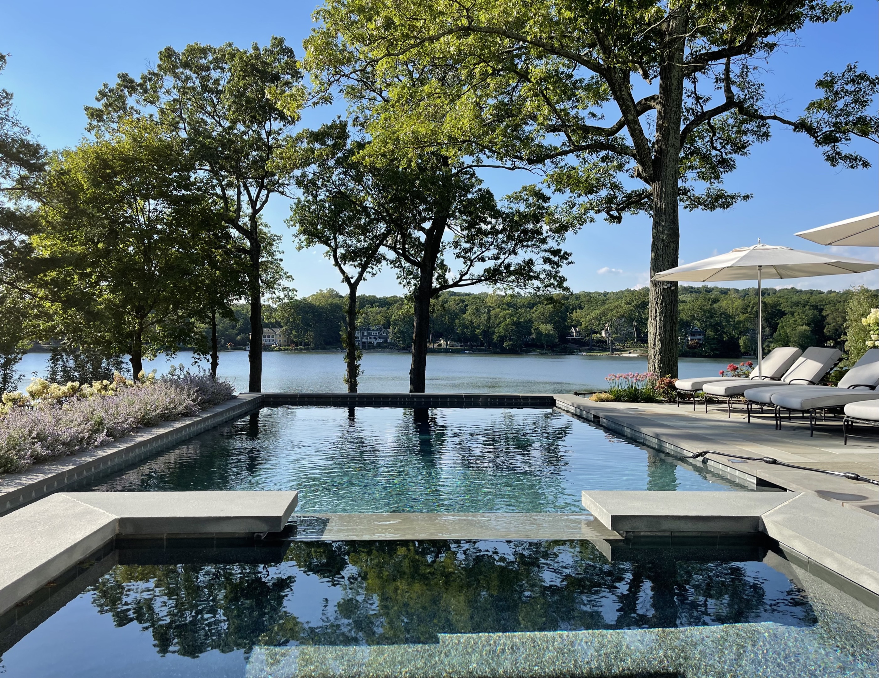 Lakefront geometric pool with infinity edge over water