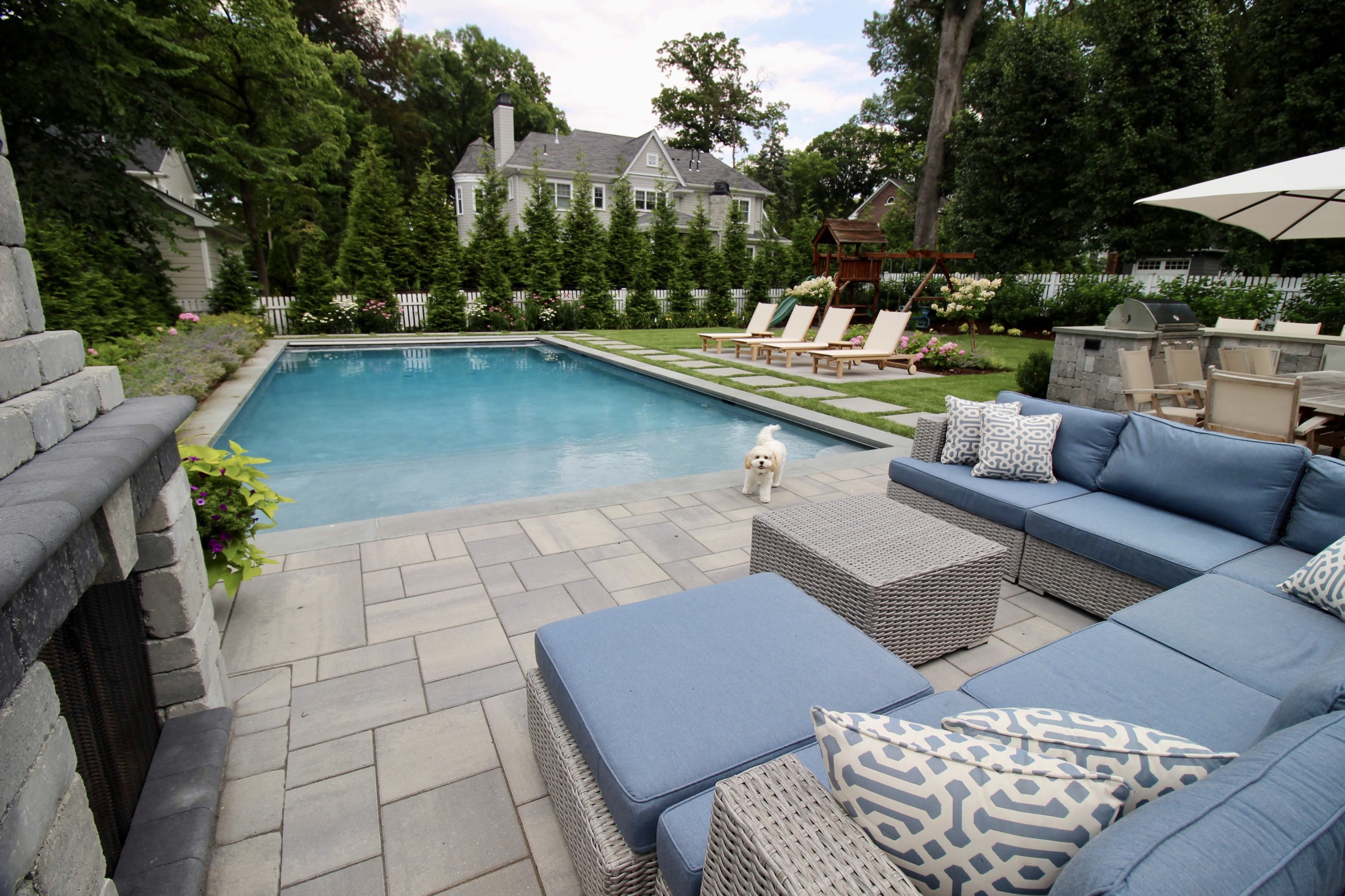 Geometric pool with bluestone patio and blue lounge sectional