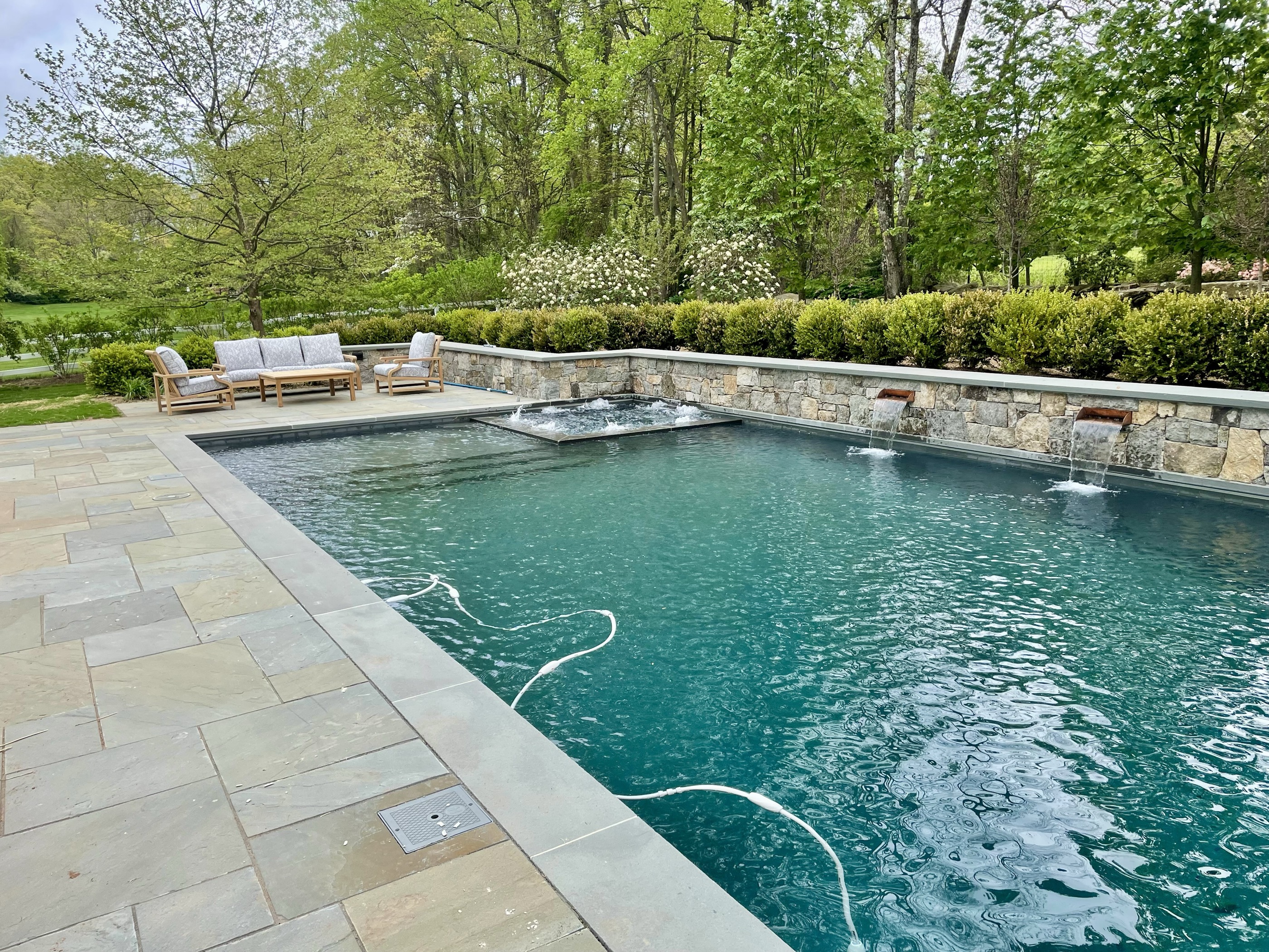 Geometric pool with raised spa and stone wall scuppers