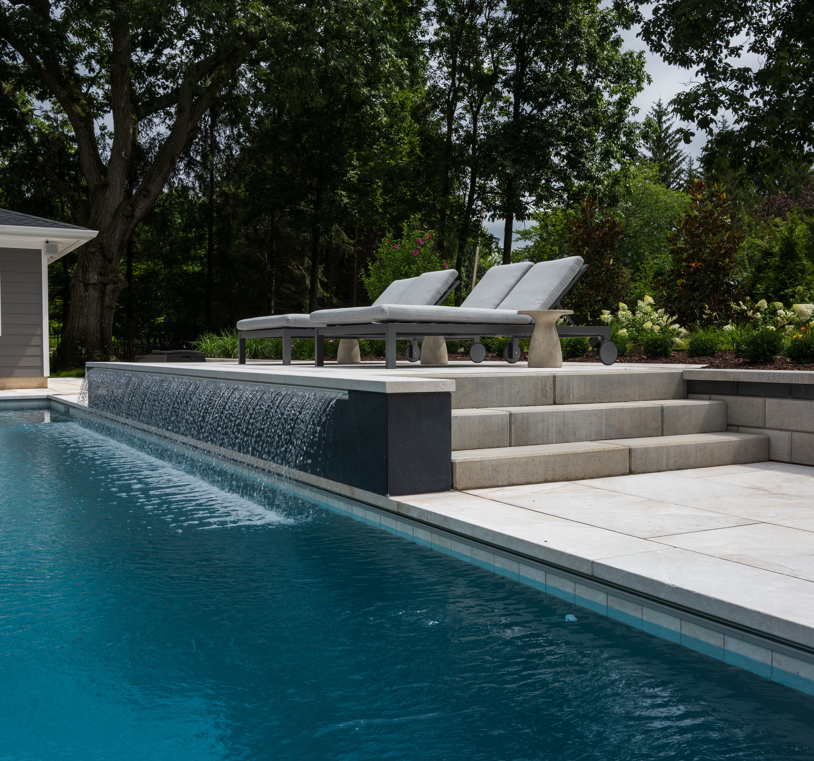Geometric pool with sheer descent waterfall and lounge deck