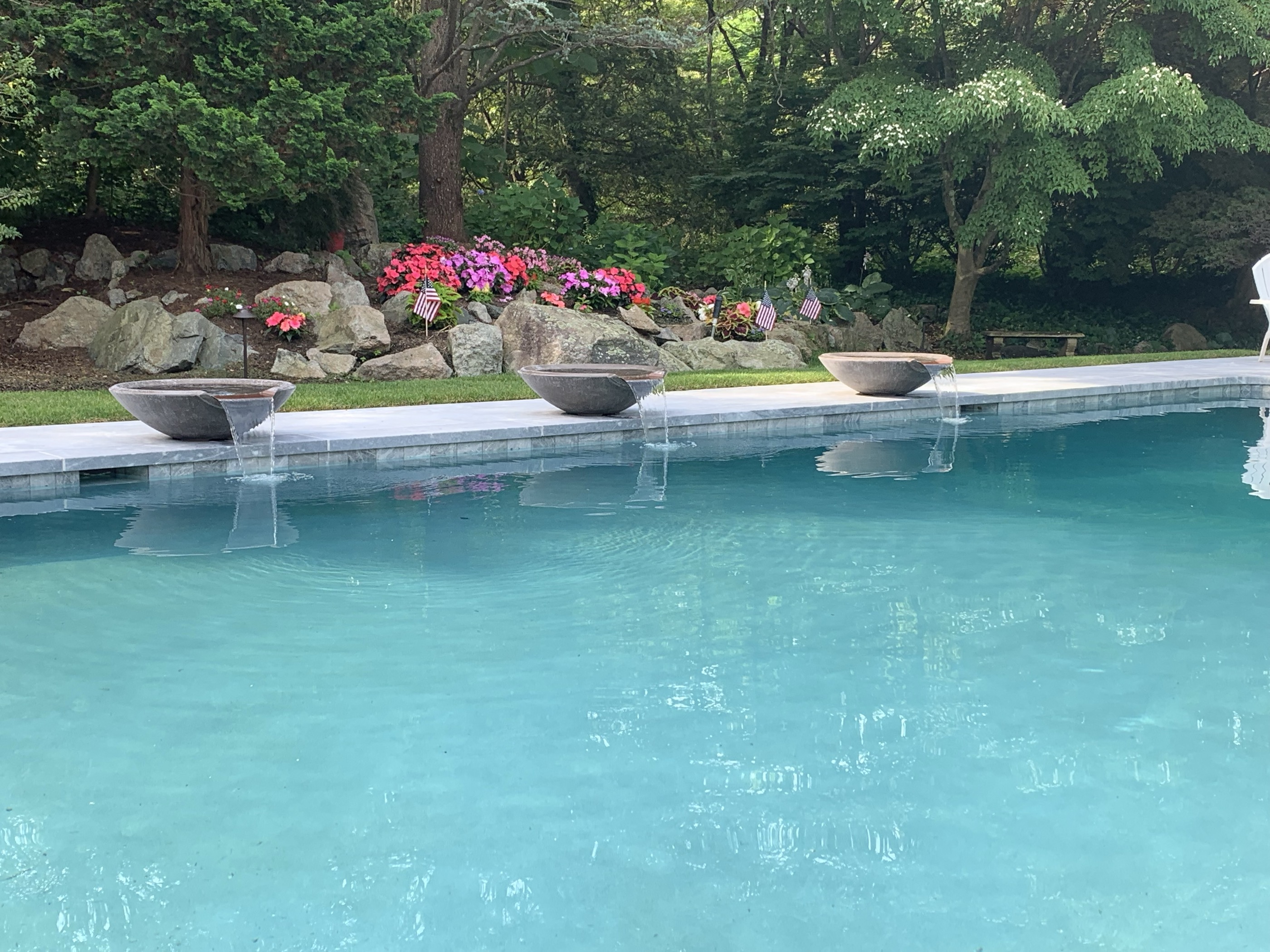 Pool with three stone water bowls and floral planting